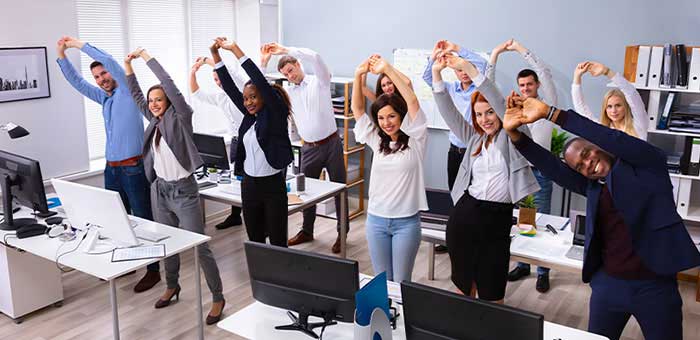 office team stretching together under guidance of Campbell chiropractor